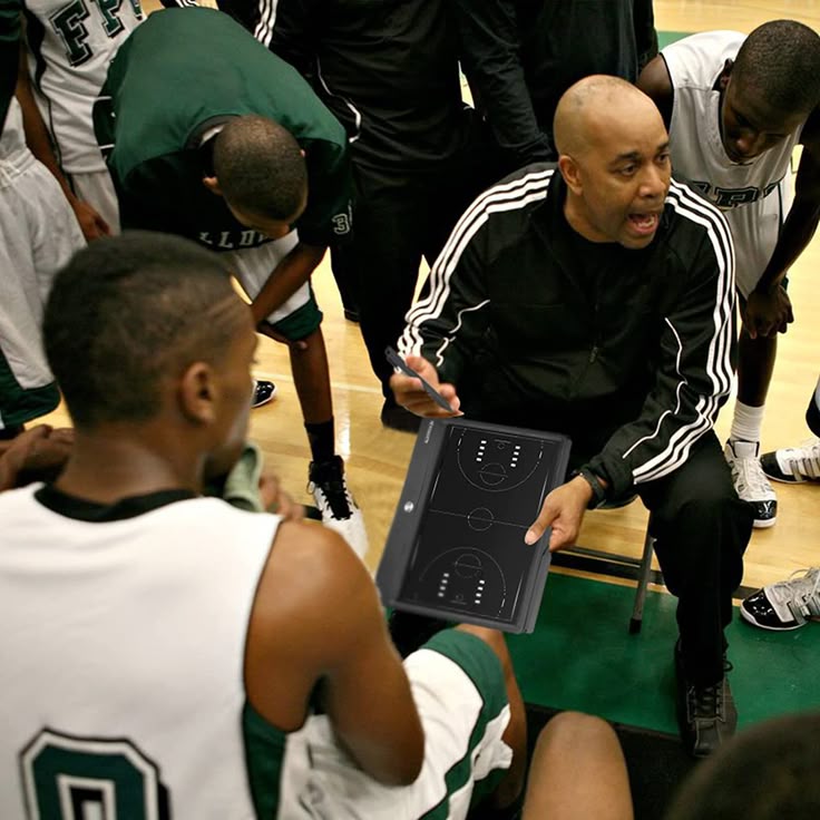 Coach analyzing basketball rebounding footage with players on a tablet
